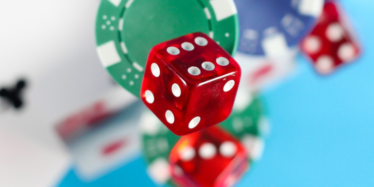 Red dice surrounded by out of focus poker chips